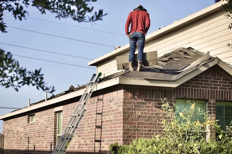 Professional roofer working on a residential roof in Afton